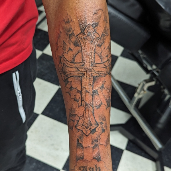 Blackwork cross with clouds and sunrays tattoo