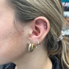 Daith with gold ring and double helix piercings