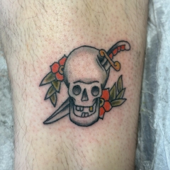 Traditional skull with dagger tattoo