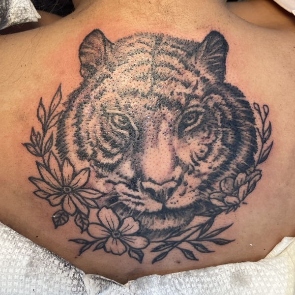 Tiger with flowers tattoo on the upper back